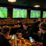 Engaging soccer fans utilizing kênh trực tiếp bóng đá hôm nay at a sports bar while cheering for their teams.