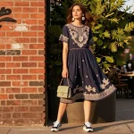 Woman showcasing a stylish modest dress against a vibrant urban backdrop, embodying modern fashion.